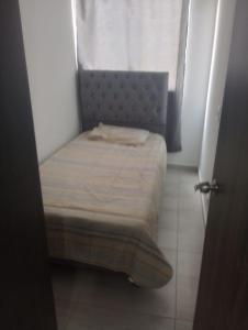 a small bed in a small room with a window at Apartahotel in Ibagué