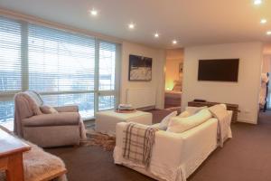 a living room with two couches and a tv at Twin Towers 102a in Mount Buller