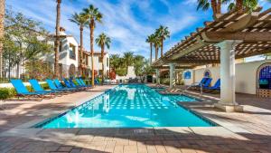 a swimming pool with blue chairs and palm trees at LV014 Legacy Villas Studio Overlooking the Pool in La Quinta