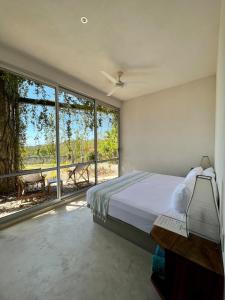 - une chambre avec un lit et une grande fenêtre dans l'établissement Casa Cascada - Adults Only, à Puerto Escondido