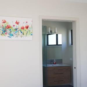 een badkamer met een wastafel en een schilderij aan de muur bij View on Kihilla in Richmond