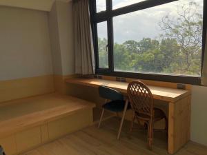 a room with a desk and a window and chairs at La Tree 普椿農場木子莊園 in Donghe