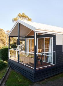 a screened in porch of a house at Surf Beach Narooma Holiday Park in Narooma