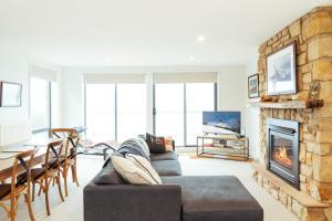 a living room with a couch and a fireplace at Candoux 4 in Mount Buller