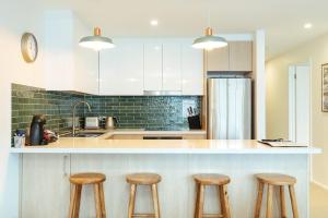 a kitchen with three stools and a counter top at Candoux 4 in Mount Buller