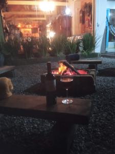 uma mesa com um copo de vinho e uma lareira em QUINTAS DA BARRA BNB a 30m da praia em Balneário Barra do Sul