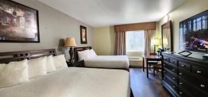 a hotel room with two beds and a desk at Crest Trail Lodge in Packwood