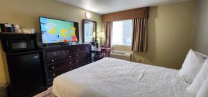 a hotel room with a bed and a flat screen tv at Crest Trail Lodge in Packwood