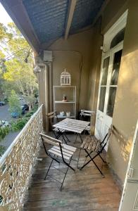 a porch with a table and chairs on it at Peaceful Haven in Sydney
