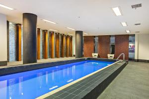 una piscina con acqua blu in un edificio di Waterfront Melbourne Apartments a Melbourne