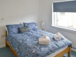 a bedroom with a bed with towels on it at Tern House in Amble