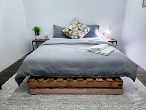 una camera con un letto e una scatola di legno sotto di Upspot Kuching Waterfront Premium Hostel a Kuching