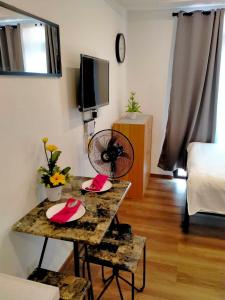 碧瑶Megatower Residence shortwalk1 SM Burnham Night Market的带桌子和电视的客厅