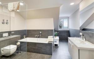 une salle de bain avec une baignoire, des toilettes et un lavabo dans l'établissement Baltischer Hof Apartment 68, à Boltenhagen