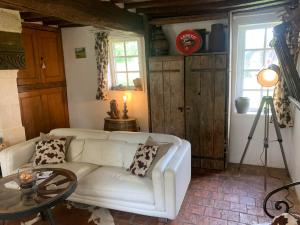a living room with a white couch and a table at Gîte " Le Normand " Sa Vue Splendide in Vimoutiers