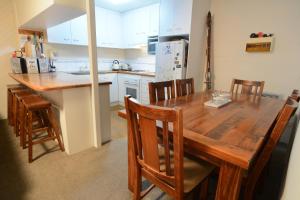 a kitchen with a wooden dining table and chairs at Molony's 12 in Mount Buller