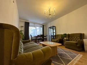 ein Wohnzimmer mit Sofas, einem Tisch und einem Kronleuchter in der Unterkunft 2 Rooms Flat with Balcony, Near of Center in Wien