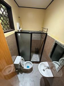a bathroom with a toilet and a sink at Fabregas Beach Cottages in El Nido