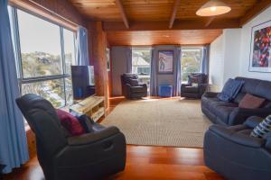een woonkamer met een bank en stoelen en een tv bij Moose 10 in Mount Buller