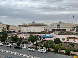 a parking lot with cars parked in front of a building at Renovated apt by the Savitsky Museum in Nukus