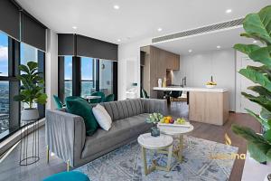 a living room with a couch and a kitchen at Lumina Suites in Melbourne