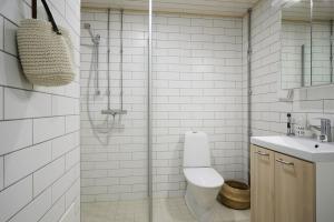 een badkamer met een douche, een toilet en een wastafel bij Fleminginkatu in Turku