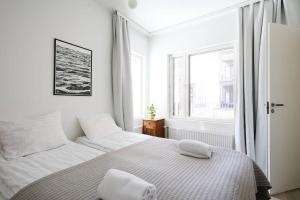 a white bedroom with a bed and a window at Fleminginkatu in Turku