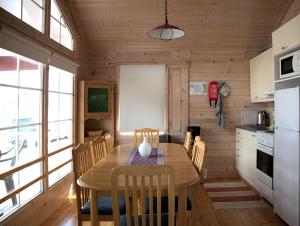 a kitchen with a wooden table and chairs in a room at Pukinsaaren Camping in Kristiinankaupunki