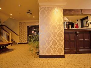 a living room with a wall with a pattern on it at Great White Horse Hotel in Ipswich