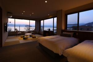 a bedroom with two beds and a view of the ocean at Suwakoen in Suwa
