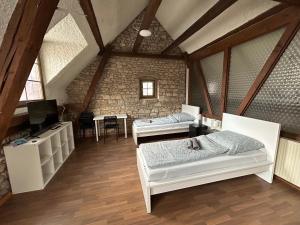 - une chambre mansardée avec 2 lits et une table dans l'établissement Weedenhof in Zornheim, à Zornheim