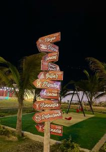 un panneau de rue avec de nombreux panneaux la nuit dans l'établissement Hostal Tropicoco, à Playas