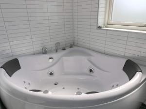 eine weiße Badewanne im Bad mit Fenster in der Unterkunft 8 person holiday home in Hadsund in Hadsund