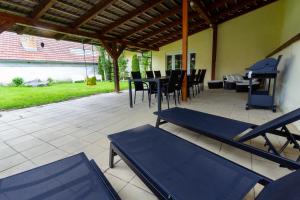 a patio with tables and chairs and a grill at Apartmánový dům Vilémovice in Vilémovice