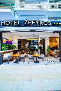 un ristorante zevros con tavoli e sedie di Hotel Zefyros a Paralia Katerinis