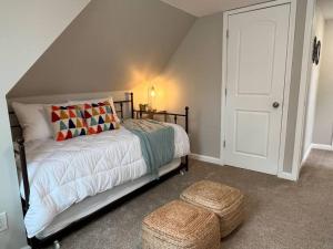 - une chambre avec un lit, une porte blanche et un tabouret dans l'établissement Cosmopolitan Comfort in St Louis MO, à Tower Grove