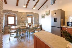 una cucina e una sala da pranzo con tavolo e frigorifero di Villa Fani with Jacuzzi a Ičići