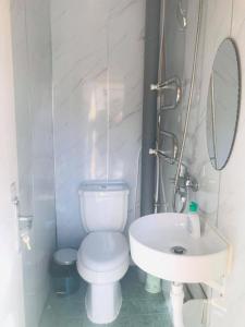 a white bathroom with a toilet and a sink at Kayak Camp, Tsonjinboldog in Narst