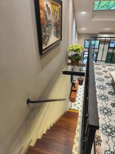 a staircase in a house with a painting on the wall at Boulevard Rollandes house in Hanoi