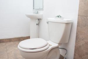 a bathroom with a white toilet and a sink at Casa Carmen in Santiago Este