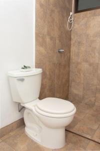 une salle de bain avec des toilettes blanches et une douche dans l'établissement Casa Carmen, à Santiago Este