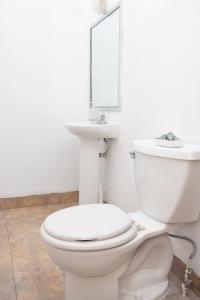 a bathroom with a white toilet and a mirror at Casa Carmen in Santiago Este