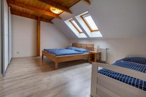 a bedroom with two beds and two skylights at Apartmánový dům Vilémovice in Vilémovice