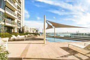 a patio with a pool and a large umbrella at LUX 52 42 Deluxe Marina view suite 1 in Dubai