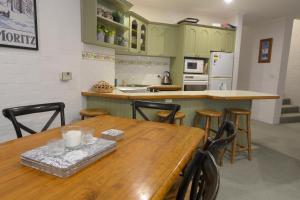 een keuken met een houten tafel en een aantal stoelen bij Beehive 14 in Mount Buller