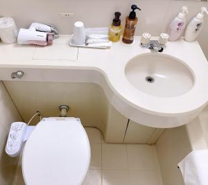 ein Badezimmer mit einem weißen Waschbecken und einer Toilette in der Unterkunft Hotel KOYO Bekkan - Vacation STAY 37027v in Hashima