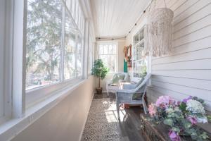 a porch with a chandelier and a chair and flowers at Craftsman's Loft - Heritage charm - AC - 5 min DT in Calgary