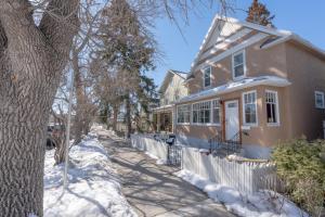 una casa in una strada con neve per terra di Craftsman's Loft - Heritage charm - AC - 5 min DT a Calgary