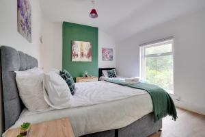 um quarto com uma cama grande e uma parede em tons de verde em Modern and Spacious 3-Bedroom House - Free Parking, Fast Wi-Fi, Ideal for up to 7 Guests em Houghton le Spring