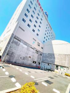 ein hohes Gebäude mit Parkplatz davor in der Unterkunft Hotel KOYO Bekkan - Vacation STAY 29013v in Hashima